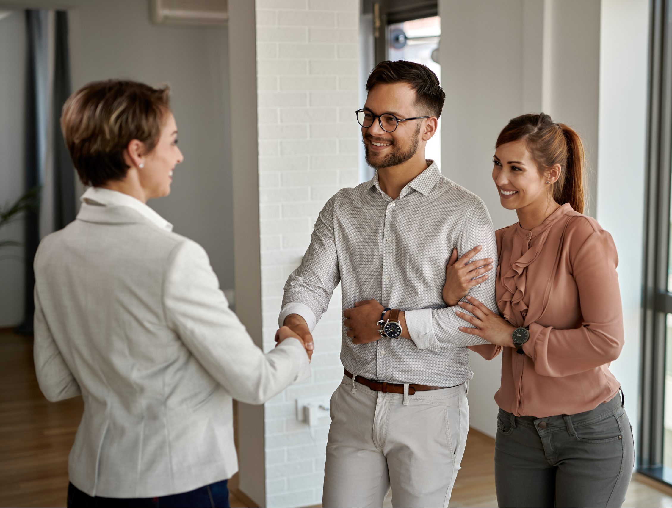 HIRING A NEW PROPERTY MANAGER Here S What To Look For Prudential   Young Happy Couple Shaking Hands With Real Estate Agent While Buying New Apartment Scaled E1685599101936 